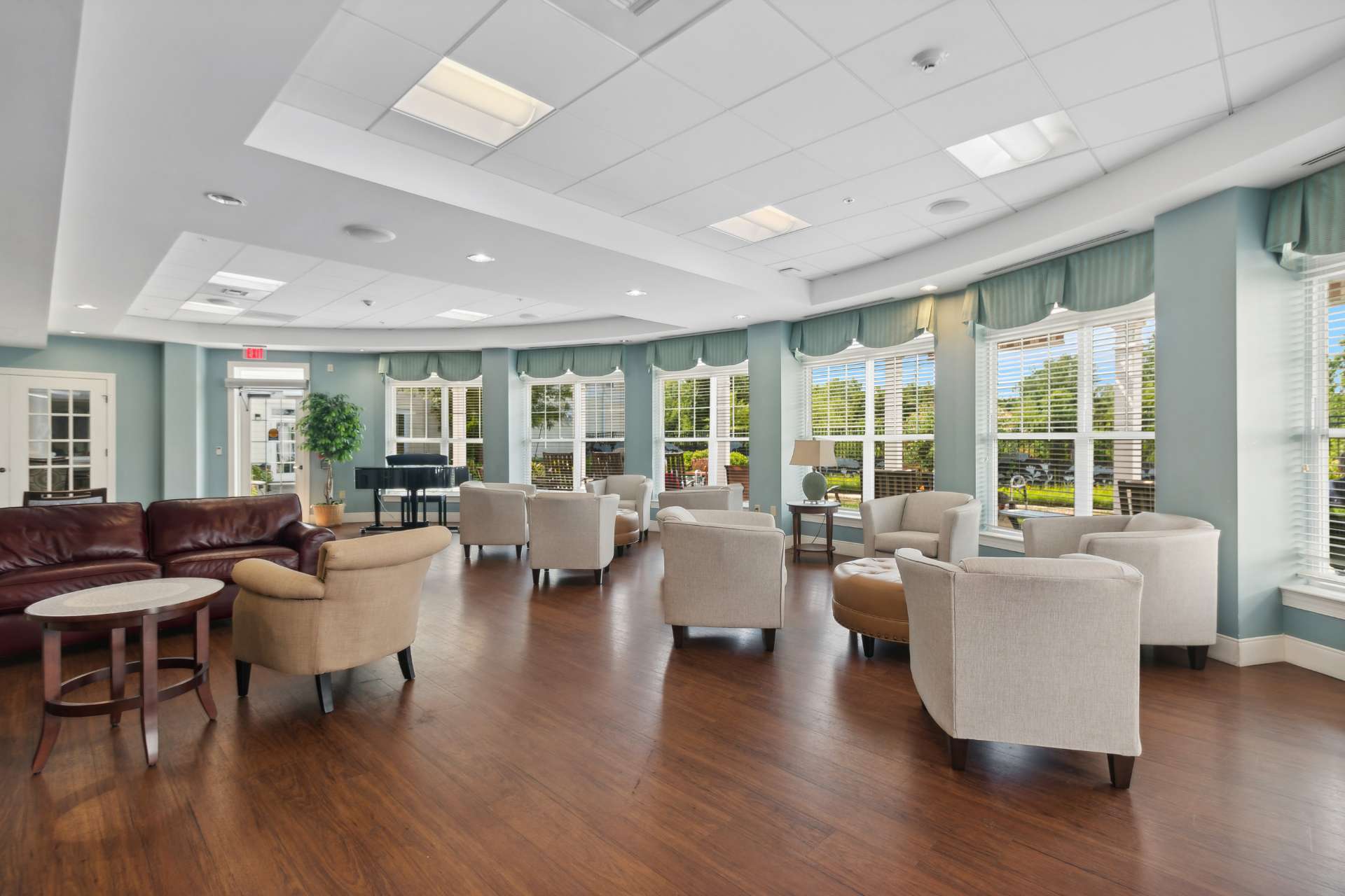 BAW_Web_CommonArea A common room with sofas, as well as chairs next to the large open windows.