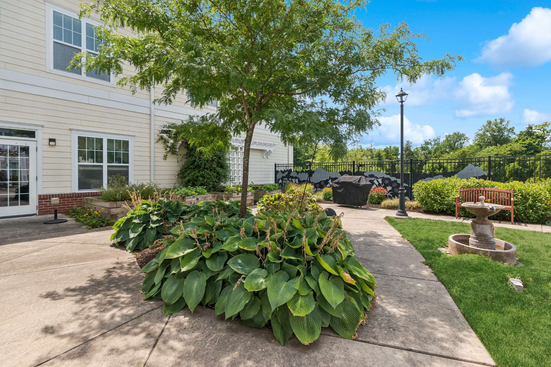 A courtyard with greenery, birdbaths, and benches.