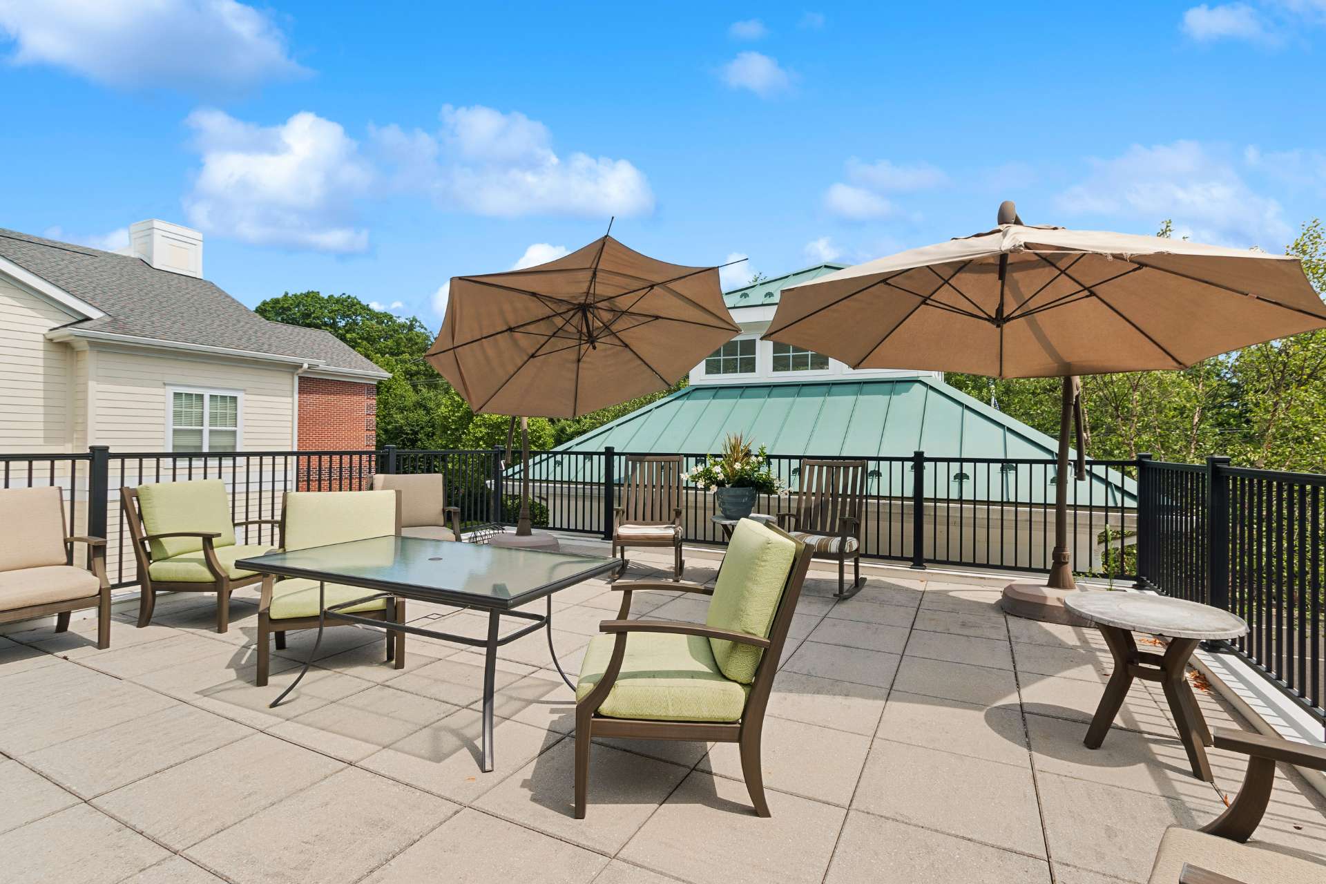 Rooftop patio seating with tables, chairs, and umbrellas.
