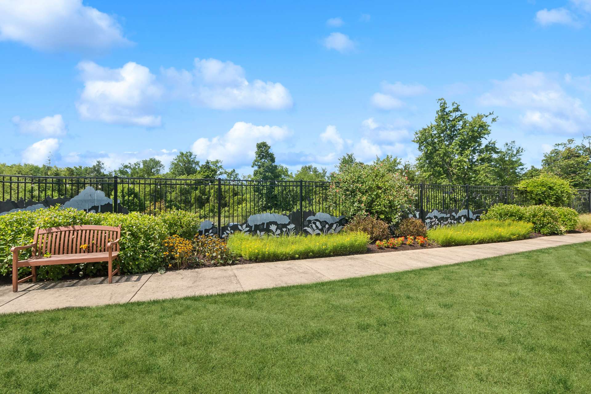 An outdoor walking path with landscaping and benches.