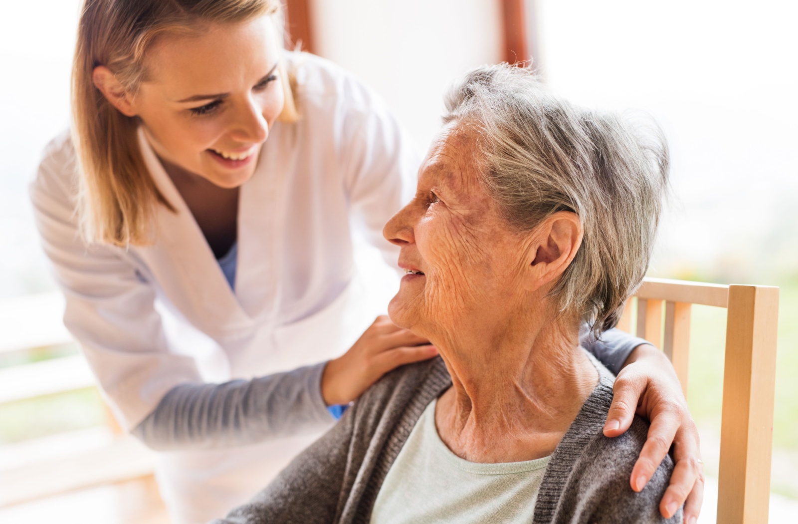 A personal care home staff checking in on a resident of a personal care home.