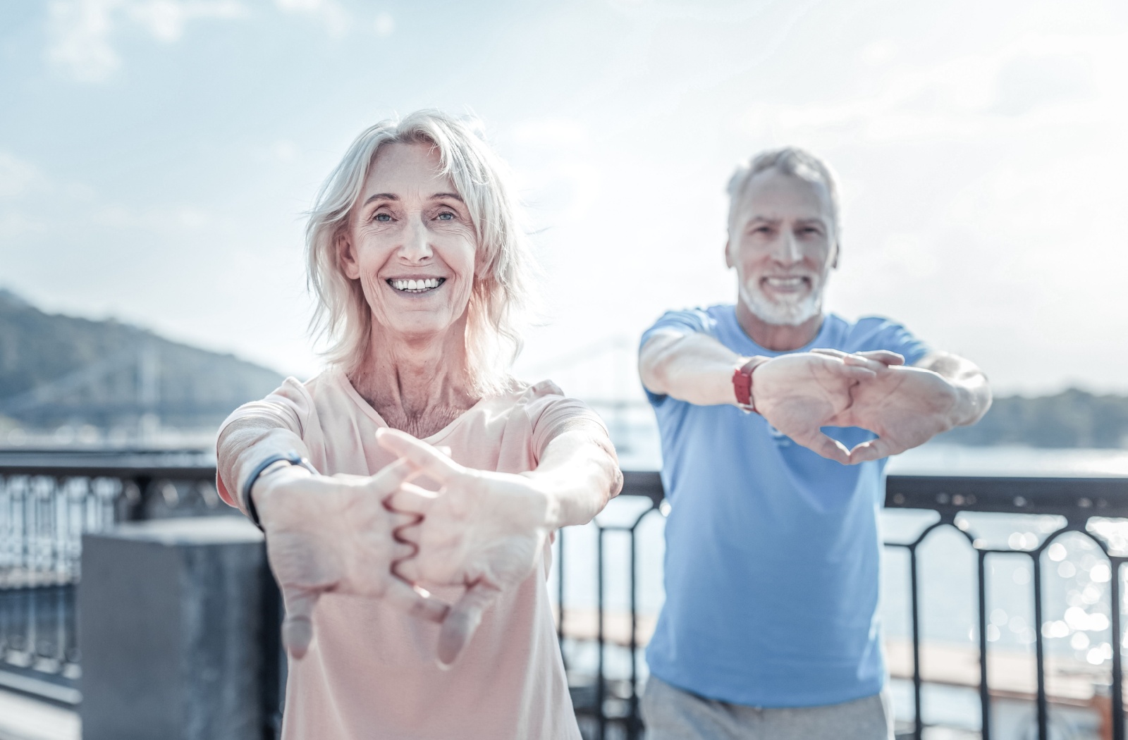 Two seniors stretch their fingers and hands while out and about the town to relieve some arthritis pain in their joints