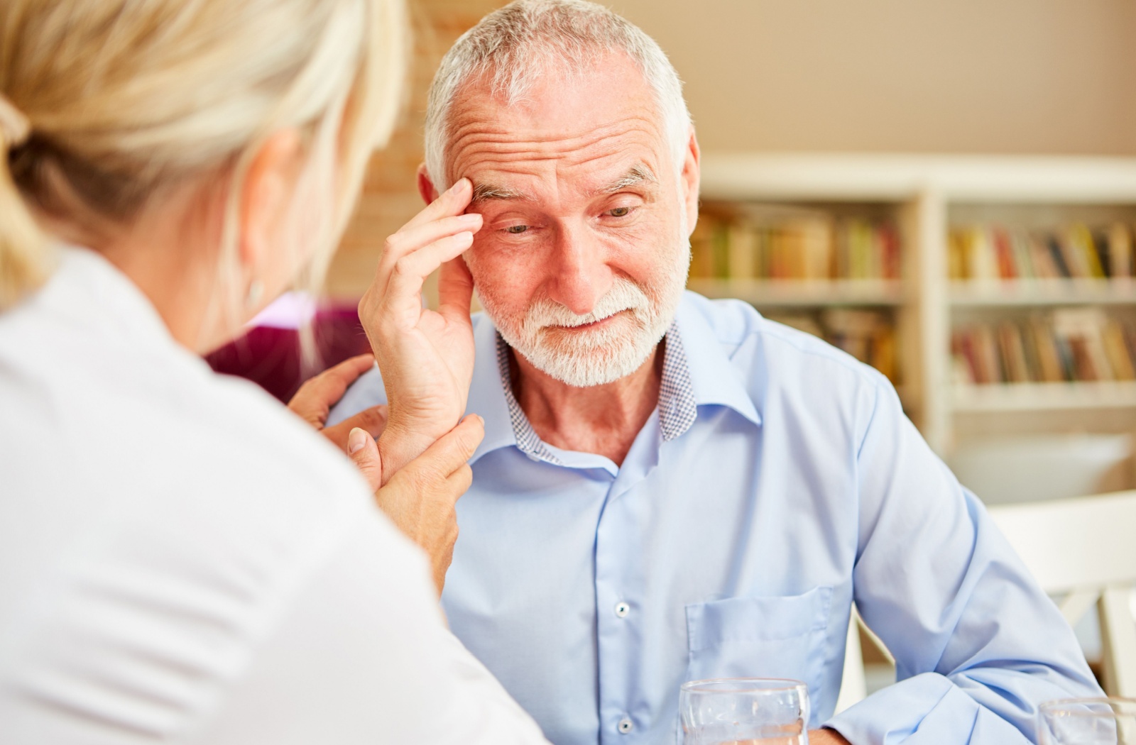 A senior with dementia, who is confused, is comforted by a caregiver.